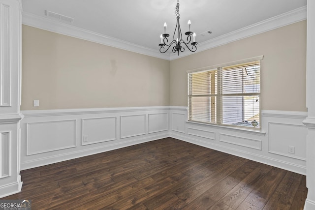 unfurnished room with crown molding, an inviting chandelier, wainscoting, and visible vents