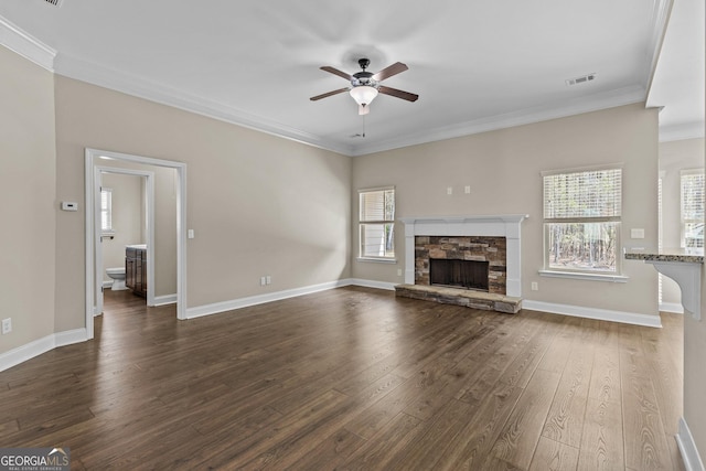 unfurnished living room featuring visible vents, ornamental molding, dark wood-style flooring, a stone fireplace, and ceiling fan