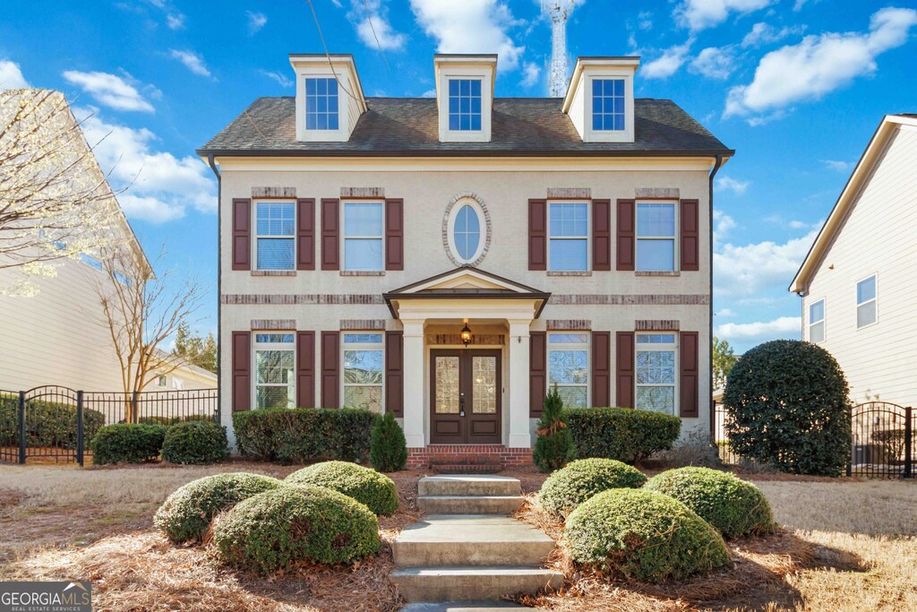 colonial home with a gate, french doors, and fence