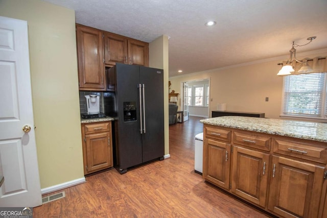 207 Lakeshore Way, Lagrange, GA 30240 - kitchen featuring black fridge, wood finished floors, crown molding, brown cabinets, and light stone counters