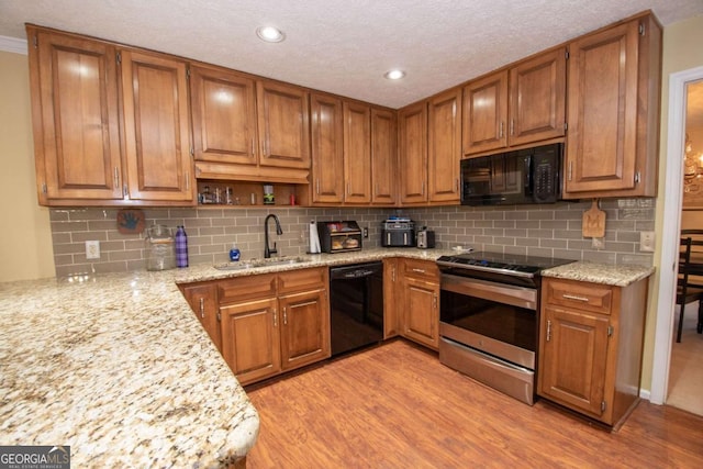 207 Lakeshore Way, Lagrange, GA 30240 - kitchen featuring black appliances, light wood-style flooring, brown cabinetry, decorative backsplash, and recessed lighting