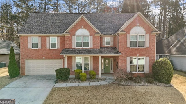 675 Timber Ives Dr, Dacula, GA 30019 - view of front facade featuring central AC, driveway, roof with shingles, brick siding, and an attached garage