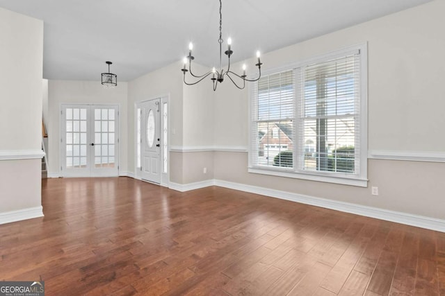 675 Timber Ives Dr, Dacula, GA 30019 - unfurnished dining area with a chandelier, wood finished floors, and baseboards