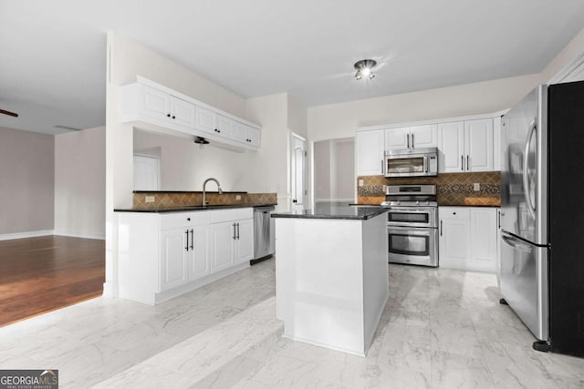 675 Timber Ives Dr, Dacula, GA 30019 - kitchen featuring appliances with stainless steel finishes, dark countertops, tasteful backsplash, a sink, and white cabinets