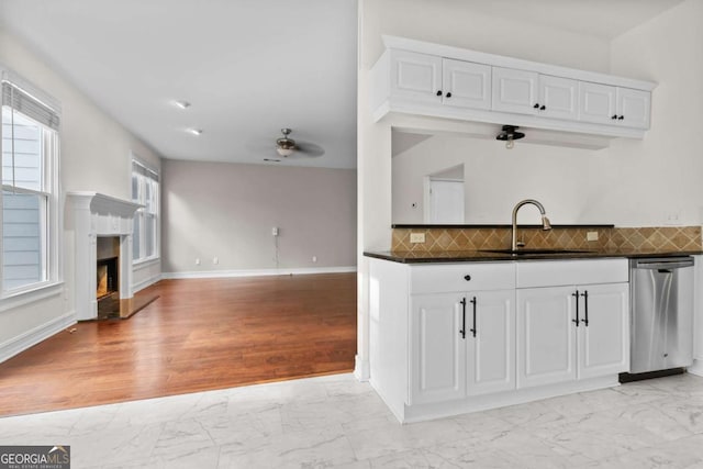 675 Timber Ives Dr, Dacula, GA 30019 - kitchen featuring a sink, light marble finish floors, stainless steel dishwasher, dark countertops, and white cabinetry