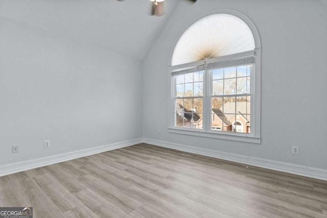 675 Timber Ives Dr, Dacula, GA 30019 - empty room with wood finished floors, vaulted ceiling, a ceiling fan, and baseboards