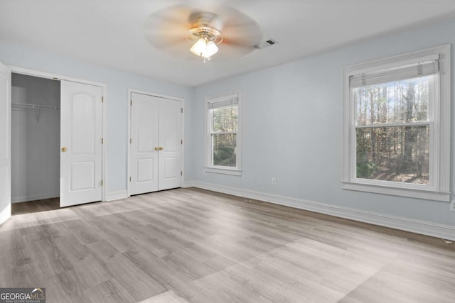 675 Timber Ives Dr, Dacula, GA 30019 - unfurnished bedroom with multiple closets, wood finished floors, and baseboards