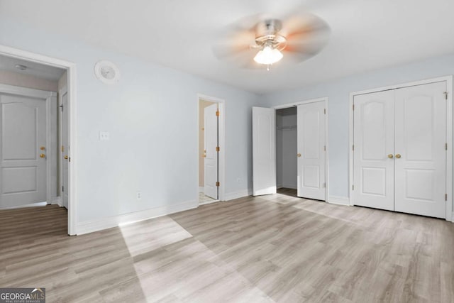 675 Timber Ives Dr, Dacula, GA 30019 - unfurnished bedroom featuring two closets, baseboards, and light wood-style flooring