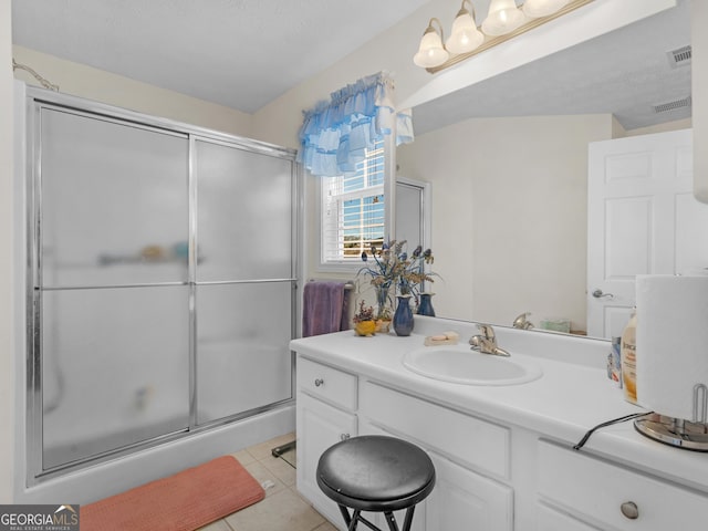 full bathroom featuring tile patterned flooring, visible vents, vanity, and a shower with shower door
