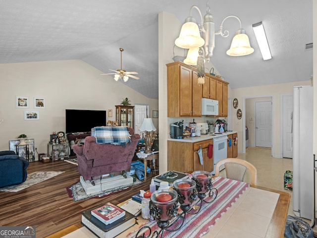 dining space featuring visible vents, a ceiling fan, a textured ceiling, light wood-style floors, and vaulted ceiling