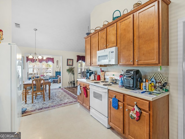 kitchen featuring white appliances, visible vents, light countertops, a notable chandelier, and brown cabinets