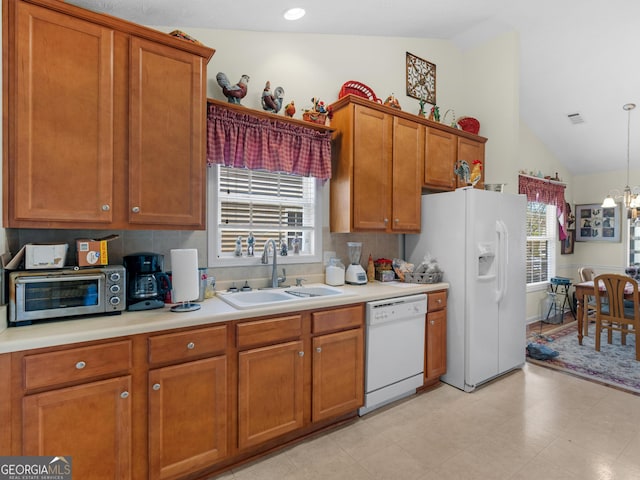 kitchen with white appliances, a sink, light countertops, brown cabinets, and a chandelier