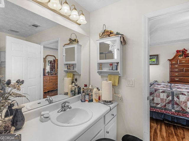 bathroom featuring visible vents, wood finished floors, and vanity