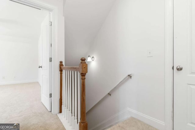unfurnished bedroom with light colored carpet, baseboards, and a spacious closet