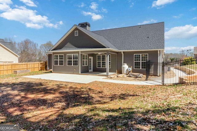 back of house with a chimney, a fenced backyard, and a patio area