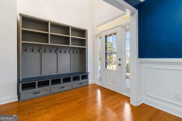 unfurnished living room with ceiling fan, a fireplace, baseboards, wood finished floors, and visible vents