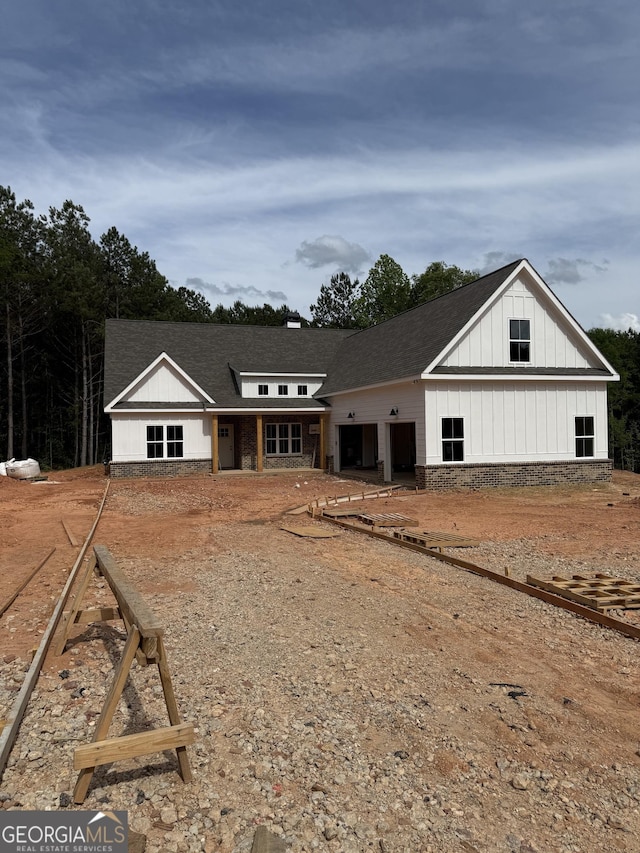 view of front facade featuring board and batten siding and a shingled roof