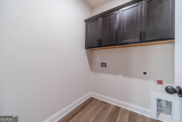clothes washing area with cabinet space, hookup for an electric dryer, wood finished floors, baseboards, and hookup for a washing machine