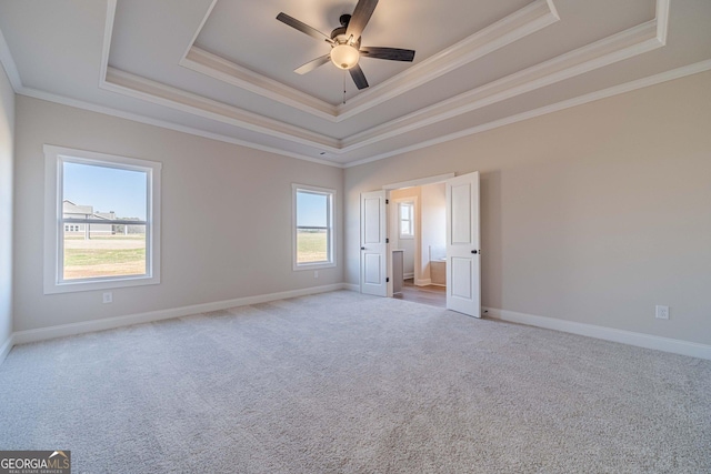 unfurnished room with a tray ceiling, crown molding, carpet floors, and ceiling fan