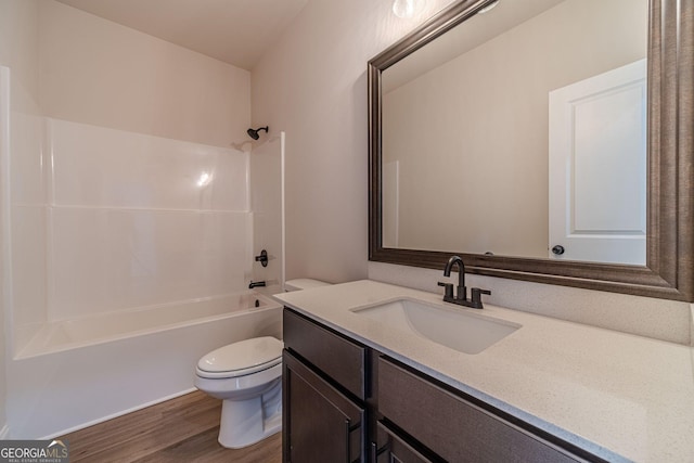 bathroom with toilet, wood finished floors, bathing tub / shower combination, and vanity