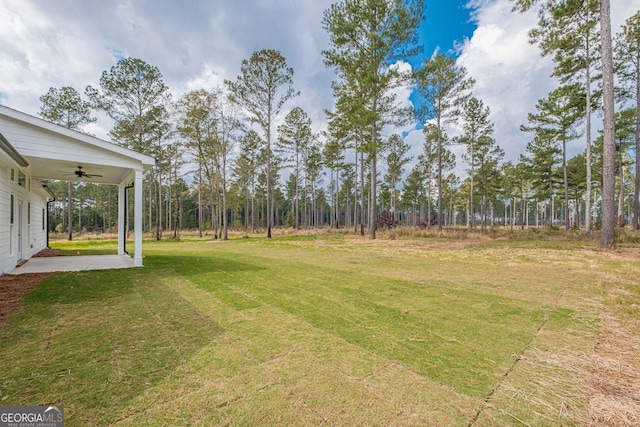 view of green lawn featuring ceiling fan and a patio