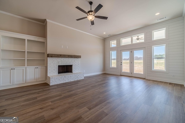 unfurnished living room featuring a ceiling fan, baseboards, ornamental molding, a brick fireplace, and dark wood-style floors