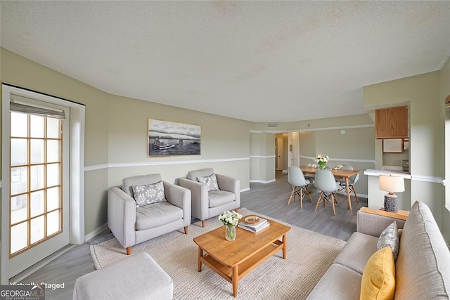 living area with light wood-type flooring and baseboards