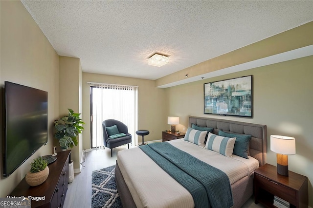 bedroom with a textured ceiling and wood finished floors