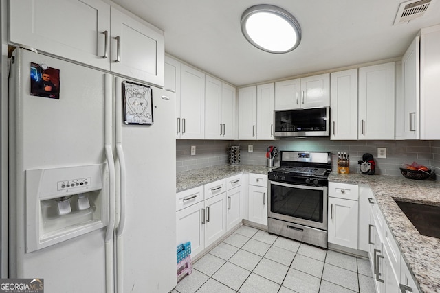 1291 Marcelle Heights Pl, Norcross, GA 30093 - kitchen featuring stainless steel appliances, backsplash, light tile patterned flooring, and white cabinets