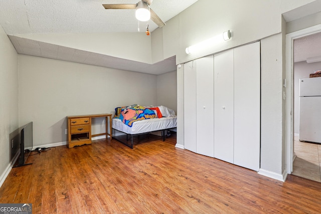 1291 Marcelle Heights Pl, Norcross, GA 30093 - bedroom with freestanding refrigerator, wood finished floors, lofted ceiling, baseboards, and a closet