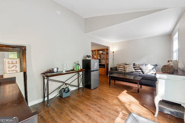 living room featuring vaulted ceiling and wood finished floors