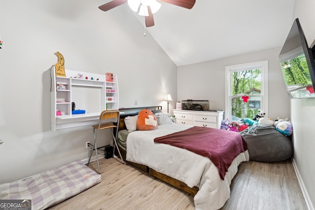 bedroom featuring baseboards, wood finished floors, high vaulted ceiling, and ceiling fan