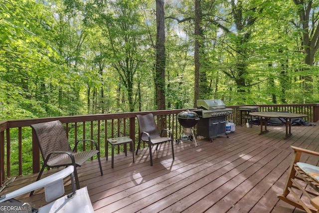 deck featuring a forest view and a grill