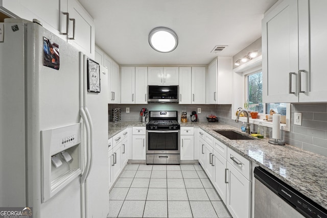 1291 Marcelle Heights Pl, Norcross, GA 30093 - kitchen with appliances with stainless steel finishes, a sink, tasteful backsplash, and white cabinetry