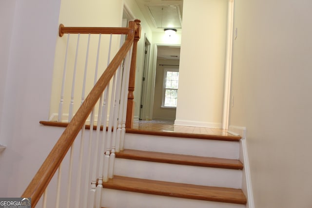 stairway featuring attic access and baseboards