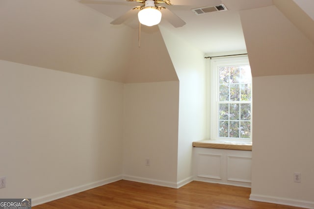 additional living space with visible vents, lofted ceiling, light wood-style floors, and ceiling fan