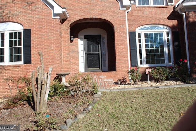 view of exterior entry with brick siding