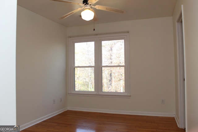 unfurnished room with ceiling fan, baseboards, and wood finished floors