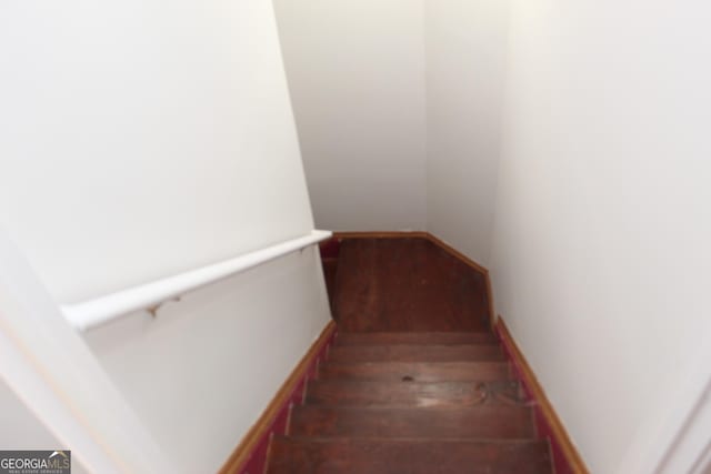 staircase with baseboards and wood finished floors