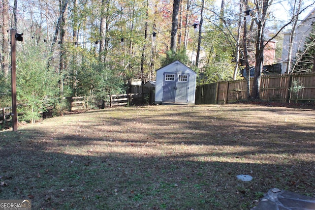 view of yard with a storage shed, fence, and an outdoor structure