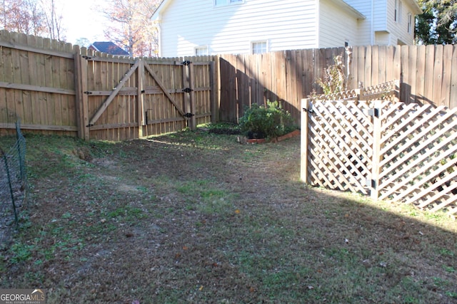 view of yard with fence and a gate