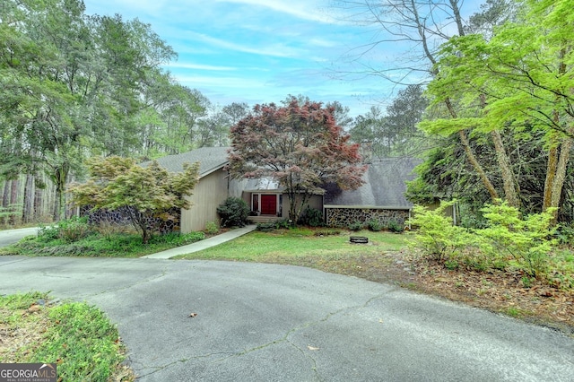 view of front of house featuring stone siding and a front lawn