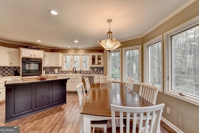 dining room with a notable chandelier, baseboards, recessed lighting, light wood-style flooring, and crown molding