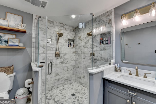 bathroom with a shower stall, vanity, and toilet