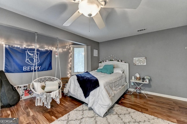 bedroom with wood finished floors, baseboards, a ceiling fan, and visible vents