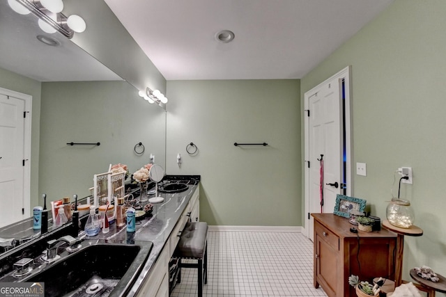 full bathroom with tile patterned floors, double vanity, baseboards, and a sink