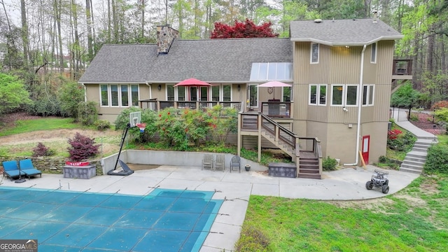 back of house with a patio, stairs, a chimney, a shingled roof, and a deck