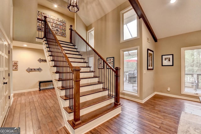 foyer entrance with baseboards, stairway, a towering ceiling, and hardwood / wood-style flooring