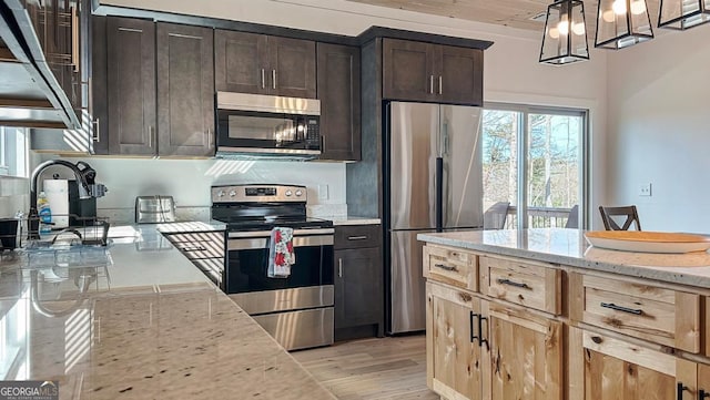 360 Prince Dr, Morganton, GA 30560 - kitchen with light stone countertops, a sink, dark brown cabinets, light wood-style floors, and appliances with stainless steel finishes