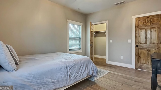 360 Prince Dr, Morganton, GA 30560 - bedroom with visible vents, baseboards, a walk in closet, and wood finished floors